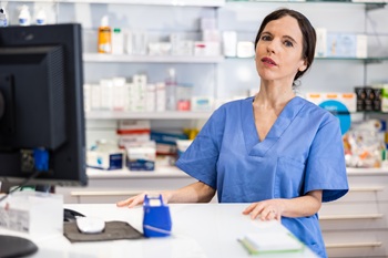 Healthcare worker entering information into computer.