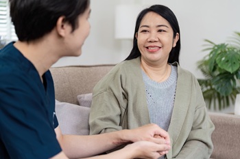 Compassionate Doctor Providing Care and Support to a Smiling Patient in a Comfortable Medical Setting.